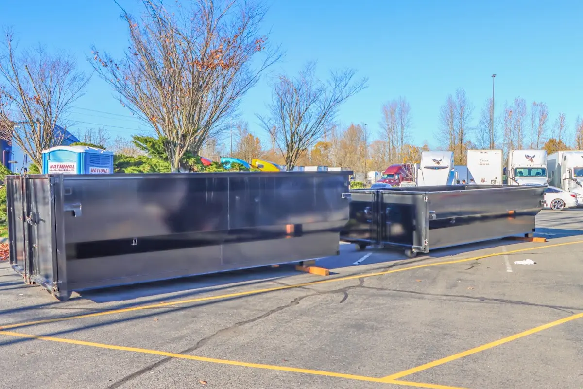 Professional dumpster rental service with roll-off container on residential driveway in Hillsdale